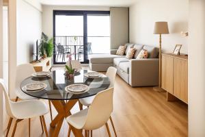 un salon avec une table, des chaises et un canapé dans l'établissement Valencia Beach Home 21, à Valence