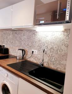 a kitchen with a sink and a stove top oven at Sadi Carnot - 1B Studio in Millau