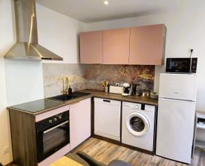 a kitchen with a washing machine and a washer at Mitrons - 1B in Saint-Affrique
