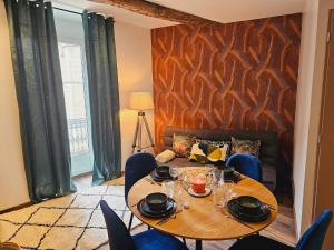 a dining room with a table and a couch at Mitrons - 1A in Saint-Affrique