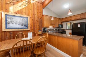 Una cocina con mesa y sillas y un refrigerador. en Pool, Hot Tubs, Sauna, Hiking from the Property, On Free Bus Route, en Winter Park