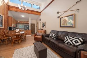 sala de estar con sofá de cuero y comedor en Pool, Hot Tubs, Sauna, Hiking from the Property, On Free Bus Route, en Winter Park