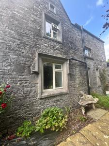 a stone house with a window and flowers in front of it at Stone Lodge Bed & Breakfast in Navan
