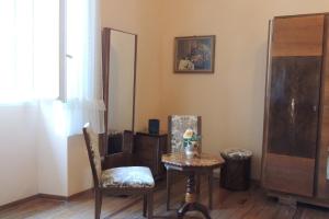 una habitación con una mesa, una silla y un espejo en B&B Villa Margherita, en Lesa