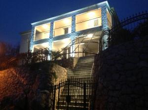 a house with lights on the side of it at MERTIK Apartment in Omišalj