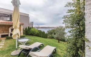 a patio with chairs and a table with a view of the water at MERTIK Apartment in Omišalj