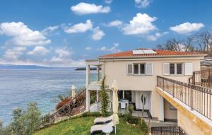 a house with a balcony overlooking the water at MERTIK Apartment in Omišalj