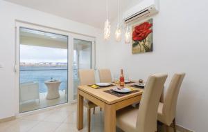 a dining room with a table and chairs and a window at MERTIK Apartment in Omišalj +8 photos