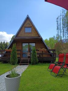 a log cabin with red chairs in front of it at Domek u Marty in Solina