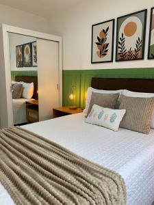 a bedroom with a large bed with a white comforter at Apart Atalaia ar cond 2 qtos in Aracaju