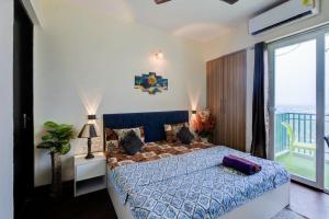 a bedroom with a blue bed and a balcony at City view stay by Royal Rooms in Noida