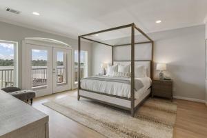 a bedroom with a canopy bed and a balcony at La Costa Drive in Montgomery
