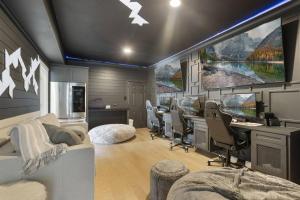 a room with a large tv and desks and chairs at La Costa Drive in Montgomery