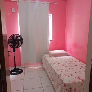 a bedroom with a bed and a pink wall at Apartamento condominiofechado in Ananindeua +7 photos