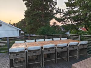 a wooden table and chairs on a deck at Sea-loving house in Åhus