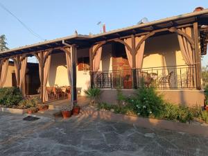 a house with a balcony with a table and chairs at Red Roses-Traditional House in Katerini