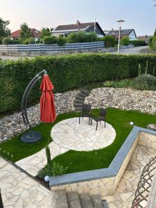 a garden with a fountain and two chairs at Casa Tandri am Rebenweg in Bermatingen