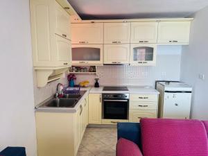 a kitchen with white cabinets and a sink at RIA apartment in Himare