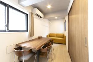 a room with a table and chairs and a couch at SLEEPLAB THE STAY Casual 池袋 -Ikebukuro- in Tokyo