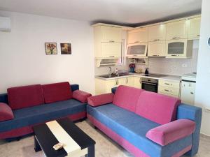 a living room with two couches and a kitchen at RIA apartment in Himare +4 photos