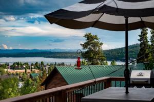a balcony with an umbrella and a view of a lake at Pool Table, Expansive Mountain Views, New Construction, Close to Town in Grand Lake