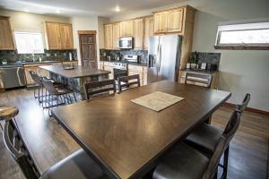 a kitchen with a wooden table and a refrigerator at Pool Table, Expansive Mountain Views, New Construction, Close to Town in Grand Lake +47 photos