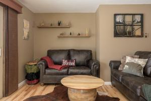 a living room with a leather couch and a table at Lula in Grand Lake