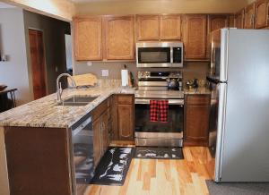 a kitchen with stainless steel appliances and wooden cabinets at Lula in Grand Lake +31 photos