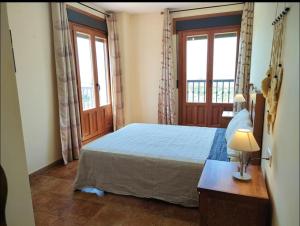 ein Schlafzimmer mit einem Bett und zwei Fenstern in der Unterkunft Colina Vacacions in Santa Clara