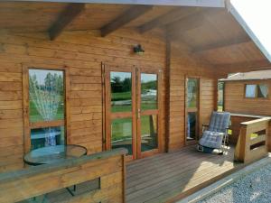 eine Blockhütte mit einem Stuhl auf einer Terrasse in der Unterkunft ENOdomki in Kwilcz
