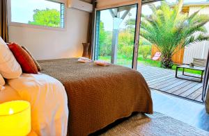 a bedroom with a bed with a view of a patio at Hôtel Latécoère in Biscarrosse