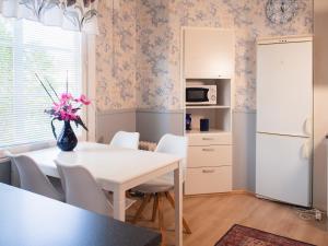 Una cocina y un comedor con una mesa y sillas blancas. en Peltohovi Guest house, en Kouvola