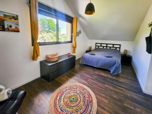 a bedroom with a bed and a window and a rug at Loft Campagnard, Jardin, Terrasse in Saint-Augustin