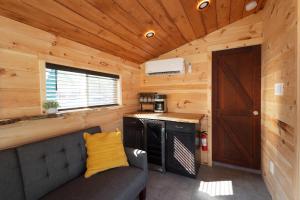 una cocina con sofá en una casa pequeña en Floating Tiny Home #1, en Vermilion