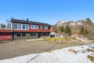 een groot rood huis met een berg op de achtergrond bij Hus i Lofoten in Kabelvåg