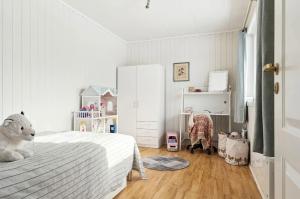 een slaapkamer met een wit bed en een witte koelkast bij Hus i Lofoten in Kabelvåg