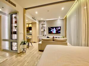 a living room with a couch and a tv at arom wongamat in Pattaya North