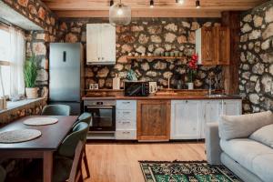 a kitchen with a refrigerator and a table and a couch at Arhetip, Djedova Villa in Žabljak