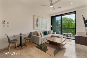 a living room with a couch and a table at Luminous 1 Br. Steps away from the Beach in Playa del Carmen