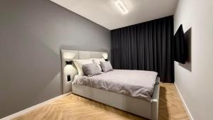 a bedroom with a bed with white sheets and pillows at Premium Apartament Boya 44 in Zgierz