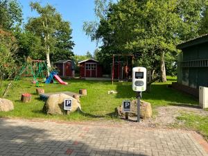a parking meter in a park with a playground at Haus Hugo Zingst in Zingst