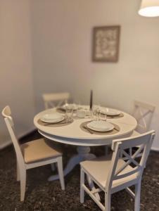 una mesa blanca con 2 sillas y una mesa con platos en ilios - urban suite, city center, en Heraclión 17 fotos más