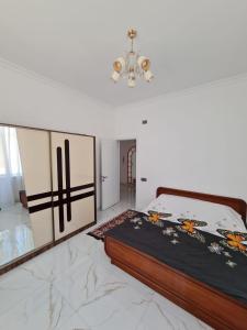 a bedroom with a bed and a chandelier at Gulu Cottage House in Mərdəkan +4 photos