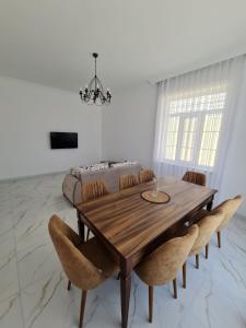 a dining room with a wooden table and chairs at Gulu Cottage House in Mərdəkan