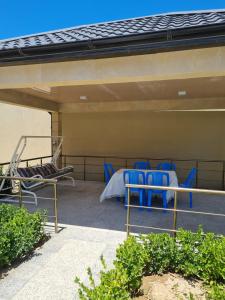 a group of blue chairs and a table on a patio at Gulu Cottage House in Mərdəkan