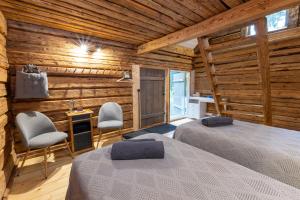 two beds in a room with wooden walls at Noorendik in Halla