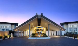 ein großes Gebäude mit einer beleuchteten Fassade in der Unterkunft Novotel Manado Golf Resort & Convention Center in Manado