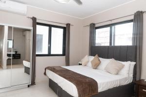 a bedroom with a large bed and a mirror at Relax Waterfront Apartments. in Bijilo +20 photos