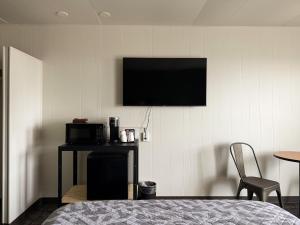 a room with a tv on a wall with a table and a chair at The Trail Inn & RV Sites - Selby, SD - HWY 12, HWY 83 in Selby