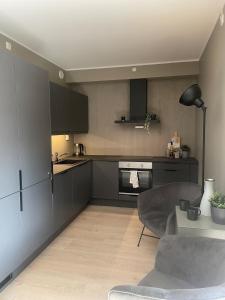 a kitchen with black cabinets and a table in a room at Familiy apartment in Myrkdalen Voss in Vossestrand